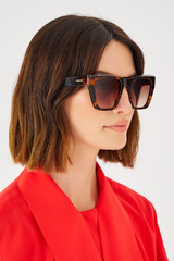 Profile view of model wearing the Oroton Cullen Sunglasses in Signature Tort and Acetate for Women