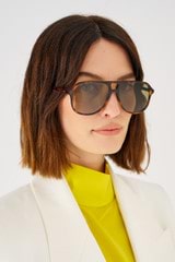Profile view of model wearing the Oroton Folk Sunglasses in Signature Tort and Acetate for 