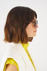 Profile view of model wearing the Oroton Folk Sunglasses in Signature Tort and Acetate for 