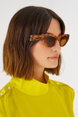 Profile view of model wearing the Oroton Rey Sunglasses in Maple Tort and Acetate for Women