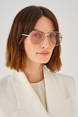 Profile view of model wearing the Oroton Valo Sunglasses in Eggshell and Metal for Women
