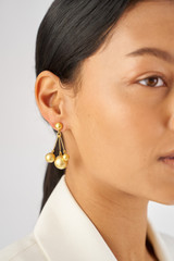 Profile view of model wearing the Oroton Bowman Cluster Earrings in Worn Gold and Brass base metal for Women