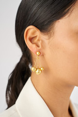 Profile view of model wearing the Oroton Bowman Cluster Earrings in Worn Gold and Brass base metal for Women
