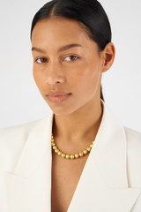 Profile view of model wearing the Oroton Bowman Necklace in Worn Gold and Brass base metal for Women