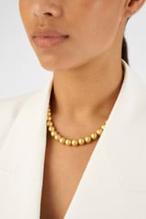 Profile view of model wearing the Oroton Bowman Necklace in Worn Gold and Brass base metal for 