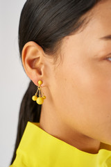 Profile view of model wearing the Oroton Bowman Small Cluster Earrings in Worn Gold/Sun and Brass base metal for Women