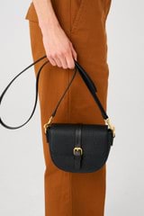 Profile view of model wearing the Oroton Dylan Small Saddle Bag in Black and Pebble leather, smooth leather trims for Women