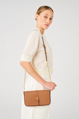 Profile view of model wearing the Oroton Dylan Clutch Crossbody in Tan and Pebble leather, smooth leather trims for Women