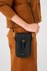Profile view of model wearing the Oroton Dylan Buckle Phone Crossbody in Black and Pebble leather. Smooth leather trims for Women