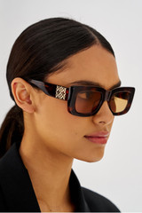 Profile view of model wearing the Oroton Alice Sunglasses in Signature Tort and Acetate for Women
