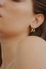 Profile view of model wearing the Oroton Kora Mini Hoops in 18K Gold and Sustainably sourced 925 Sterling Silver for Women