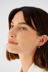 Profile view of model wearing the Oroton Kora Mini Hoops in Silver and Recycled 925 Sterling Silver for Women