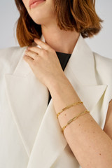 Profile view of model wearing the Oroton Gianna Paper Link Chain Bracelet in 18K Gold and Recycled 925 Sterling Silver for Women