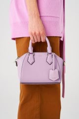 Profile view of model wearing the Oroton Inez Tiny Day Bag in Lilac and Saffiano Leather for Women