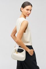 Profile view of model wearing the Oroton Clara Mini Bag in Paper White and Pebble leather for Women