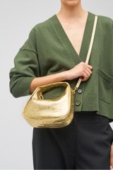 Profile view of model wearing the Oroton Clara Mini Bag in Gold and Metallic crinkle leather for Women