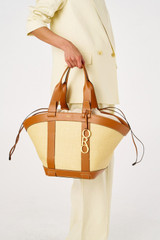 Profile view of model wearing the Oroton Harper Large Tote in Natural/Brandy and Woven straw with smooth leather trims for Women