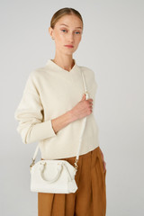 Profile view of model wearing the Oroton Inez Tiny Day Bag in Cream and Saffiano Leather for Women