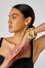 Profile view of model wearing the Oroton Conch Cuff in Worn Gold/Clear and Brass for Women