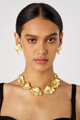 Profile view of model wearing the Oroton Conch Necklace in Worn Gold/Clear and Brass for Women