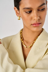 Profile view of model wearing the Oroton Isla Wide Hoop in Worn Gold and Brass for Women