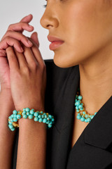 Profile view of model wearing the Oroton Jupiter Bracelet in Worn Gold/Turquoise and Brass for Women