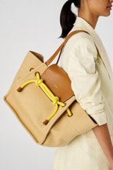 Profile view of model wearing the Oroton Otis Tote in Camel/Amber and Canvas for Women