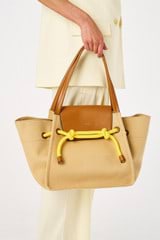 Profile view of model wearing the Oroton Otis Tote in Camel/Amber and Canvas for Women