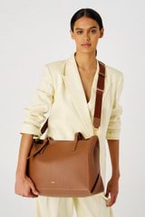 Profile view of model wearing the Oroton Margot Baby Bag in Whiskey and Pebble leather for Women