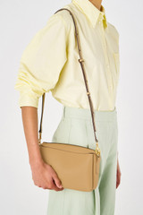Profile view of model wearing the Oroton Alice Crossbody in Camel and Pebble leather for Women
