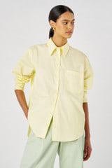 Profile view of model wearing the Oroton Poplin Long Sleeve Shirt in Lemon Curd and 100% cotton for Women