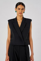 Profile view of model wearing the Oroton Tuxedo Vest in Black and 53% Polyester, 42% Wool, 5% Elastane for Women