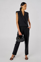 Profile view of model wearing the Oroton Tuxedo Vest in Black and 53% Polyester, 42% Wool, 5% Elastane for Women