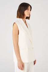Profile view of model wearing the Oroton Sleeveless Waiter's Jacket in Cream and 58% viscose, 42% linen for Women