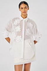 Profile view of model wearing the Oroton Lace Flower Sheer Overshirt in Antique White and 100% Cotton for Women