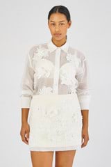 Profile view of model wearing the Oroton Lace Flower Mini Skirt in Soft Cream and sheer organdy: 100% Cotton 
skirt base: 100% Linen for Women