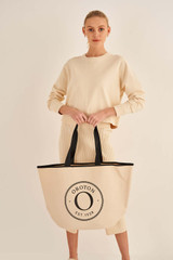 Profile view of model wearing the Oroton Kaia Shopper Tote in Natural/Black and Coated Canvas for Women