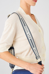Profile view of model wearing the Oroton Heather Long Webbing Strap in Dark Navy/Natural and Pebble Leather for Women