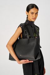 Profile view of model wearing the Oroton Margot Baby Bag in Black and Pebble leather for Women