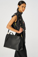 Profile view of model wearing the Oroton Margot Baby Bag in Black and Pebble leather for Women