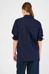 Profile view of model wearing the Oroton Poplin Long Sleeve Shirt in North Sea and 100% cotton for Women