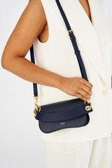 Profile view of model wearing the Oroton Liv Small Day Bag in Fisherman Blue and Pebble leather for Women