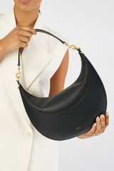Profile view of model wearing the Oroton Florence Medium Hobo in Black and Smooth leather for Women
