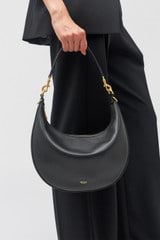 Profile view of model wearing the Oroton Florence Medium Hobo in Black and Smooth leather for Women