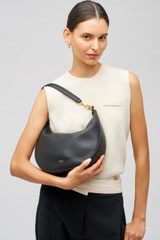 Profile view of model wearing the Oroton Florence Medium Hobo in Black and Smooth leather for Women