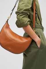 Profile view of model wearing the Oroton Florence Medium Hobo in Cognac and Smooth leather for Women
