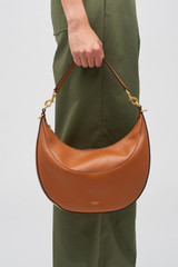 Profile view of model wearing the Oroton Florence Medium Hobo in Cognac and Smooth leather for Women