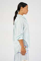 Profile view of model wearing the Oroton Silk Long Sleeve Shirt in Pale Blue and 100% silk for Women