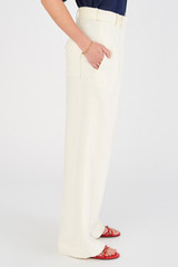 Profile view of model wearing the Oroton Tab Detail Pleat Pant in Cream and 100% linen for Women
