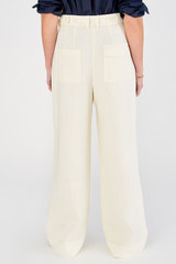 Profile view of model wearing the Oroton Tab Detail Pleat Pant in Cream and 100% linen for Women